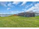 A well-maintained backyard features a screened-in pool and lush green lawn, with a view of the serene lake at 17502 Savory Mist Cir, Bradenton, FL 34211