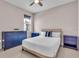 Cozy bedroom with neutral walls and blue dressers illuminated by a ceiling fan at 17502 Savory Mist Cir, Bradenton, FL 34211