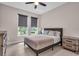 Cozy bedroom with dual windows, stylish window shades, ceiling fan, and a comfortable bed with coordinating nightstands at 17502 Savory Mist Cir, Bradenton, FL 34211