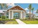 Exterior of the clubhouse featuring a covered entrance, manicured landscaping, and a paved walkway at 17502 Savory Mist Cir, Bradenton, FL 34211