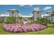 Community clubhouse entry with beautiful flowerbeds and manicured landscaping leading to the pool at 17502 Savory Mist Cir, Bradenton, FL 34211