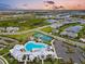Aerial view of a vibrant community pool, tennis courts, and playground at 17502 Savory Mist Cir, Bradenton, FL 34211
