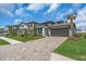 Street view of house with a two car garage, nicely landscaped yard, and a paver driveway at 17502 Savory Mist Cir, Bradenton, FL 34211