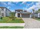 Well maintained lawn view of house with a two car garage, landscaped yard, and paver driveway at 17502 Savory Mist Cir, Bradenton, FL 34211