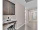 Bright hallway with tiled floors, leading to a workstation nook with custom cabinetry and a built-in desk with a chair at 17502 Savory Mist Cir, Bradenton, FL 34211