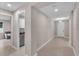 Hallway leading to the front door and laundry room, all neutrally painted at 17502 Savory Mist Cir, Bradenton, FL 34211