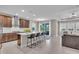 Open-concept kitchen featuring a large island with bar seating, stainless steel appliances, and an adjacent dining area at 17502 Savory Mist Cir, Bradenton, FL 34211