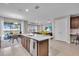 Spacious kitchen with white countertop island, leading to dining area and living space, creating an open floor plan at 17502 Savory Mist Cir, Bradenton, FL 34211