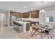 Well-lit kitchen with wooden cabinets, stainless steel appliances, a marble backsplash, and an island with bar seating at 17502 Savory Mist Cir, Bradenton, FL 34211