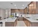 Modern kitchen with stainless steel appliances, dark wood cabinets, and a spacious island with white countertop at 17502 Savory Mist Cir, Bradenton, FL 34211