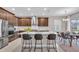 Modern kitchen with stainless steel appliances, a marble backsplash, an island with bar seating, and a dining table at 17502 Savory Mist Cir, Bradenton, FL 34211