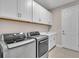Laundry room with modern washer and dryer, sink, and white cabinets at 17502 Savory Mist Cir, Bradenton, FL 34211