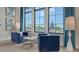 Stylish seating area with plush blue chairs, chess set and large windows overlooking a pool at 17502 Savory Mist Cir, Bradenton, FL 34211