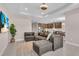 Open-concept living room with a gray sectional sofa, leading into the kitchen and dining area at 17502 Savory Mist Cir, Bradenton, FL 34211