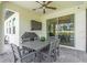 Covered patio with outdoor dining table and chairs, ceiling fan, and mounted television set at 17502 Savory Mist Cir, Bradenton, FL 34211