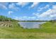 A calming pond is the focal point, surrounded by lush greenery, offering a tranquil view for neighborhood residents at 17502 Savory Mist Cir, Bradenton, FL 34211