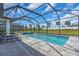 A screened-in swimming pool features an attached spa, gray pavers, and a view of the green lawn at 17502 Savory Mist Cir, Bradenton, FL 34211