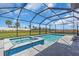 A blue tiled spa adjoins the swimming pool under the screen, with gray pavers and a grass lawn at 17502 Savory Mist Cir, Bradenton, FL 34211