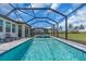 The screened-in pool has a spa, gray pavers surround it, and there is a view of the green grass at 17502 Savory Mist Cir, Bradenton, FL 34211
