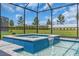 The blue tiled spa features a waterfall feature and sits alongside the swimming pool with a screen at 17502 Savory Mist Cir, Bradenton, FL 34211