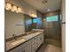Modern bathroom with double vanity, granite countertop, and glass-enclosed shower at 18044 Cherished Loop, Bradenton, FL 34211