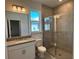Bright bathroom with granite countertop vanity and glass-enclosed shower with gray tiling at 18044 Cherished Loop, Bradenton, FL 34211