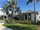 Exterior view of a beautifully landscaped home with mature palm trees and well-maintained lawn at 18044 Cherished Loop, Bradenton, FL 34211