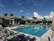 Stunning community pool featuring sun loungers, palm trees, and a beautiful building with elegant architectural details at 18044 Cherished Loop, Bradenton, FL 34211