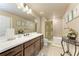 Neutral colored bathroom with a large mirror, floral accents, and great lighting at 19921 Petrino St, Venice, FL 34293