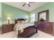Beautiful bedroom featuring dark wood furniture, ceiling fan, and bright green walls at 19921 Petrino St, Venice, FL 34293
