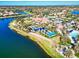 Aerial view shows the community's swimming pool, parking, lawns, and recreation area on the lake at 19921 Petrino St, Venice, FL 34293