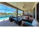 Spacious screened in lanai featuring lake views, comfortable seating, and a fire pit at 19921 Petrino St, Venice, FL 34293