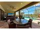Inviting outdoor dining area featuring a round glass table, seating, and a lake view at 19921 Petrino St, Venice, FL 34293