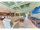 Open-concept living space with green walls, coffered ceiling, and access to the kitchen and dining area at 19921 Petrino St, Venice, FL 34293