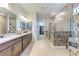 Bathroom featuring double sinks with granite countertops, a glass-enclosed shower, and a walk-in closet at 19921 Petrino St, Venice, FL 34293