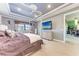 Spacious main bedroom featuring a decorative ceiling, television, and a glimpse of the in-house bar at 19921 Petrino St, Venice, FL 34293