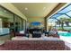Relax on this covered lanai featuring comfortable seating, a TV, and a view of the pool at 19921 Petrino St, Venice, FL 34293