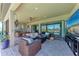 A covered patio with comfortable wicker furniture and a view of the pool at 19921 Petrino St, Venice, FL 34293