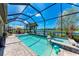Sparkling pool and spa area with a screened enclosure and serene lake view, perfect for outdoor relaxation and entertaining at 19921 Petrino St, Venice, FL 34293