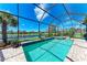 Inviting backyard pool and hot tub with screened enclosure, lake views, and beautiful landscaping at 19921 Petrino St, Venice, FL 34293