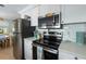 Modern kitchen featuring stainless steel appliances, white cabinets, and quartz countertops at 214 Palm Ave, Anna Maria, FL 34216