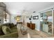 Comfortable living room with green sofa, glass table, TV, and sliding doors to the outdoor area at 214 Palm Ave, Anna Maria, FL 34216