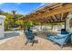 Relaxing covered patio with outdoor seating, dining area, and a grill, creating an inviting space for relaxation and entertainment at 214 Palm Ave, Anna Maria, FL 34216