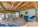 Enjoy this covered patio with ceiling fan, dining table, grill, and relaxing seating, ideal for outdoor living and entertaining at 214 Palm Ave, Anna Maria, FL 34216