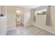 Bright room with white tile flooring, a window, and a walk-in closet to the bathroom at 22209 Breezeswept Ave, Port Charlotte, FL 33952