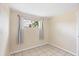 This tiled bedroom has a window with curtains and neutral wall color at 22209 Breezeswept Ave, Port Charlotte, FL 33952