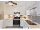 Well-lit kitchen featuring stainless steel appliances, tiled floor, and white cabinets at 22209 Breezeswept Ave, Port Charlotte, FL 33952