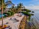 Aerial shot of a sandy beach with lounge chairs, tropical trees, and shoreline at 319 Compass Point Dr # 201, Bradenton, FL 34209