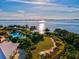 Stunning aerial view showcases the waterfront property, swimming pool, lush landscaping, and access to the bay at 319 Compass Point Dr # 201, Bradenton, FL 34209