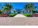 Beautiful building with a manicured lawn, red brick entry, and lush landscaping and tall palm trees at 319 Compass Point Dr # 201, Bradenton, FL 34209